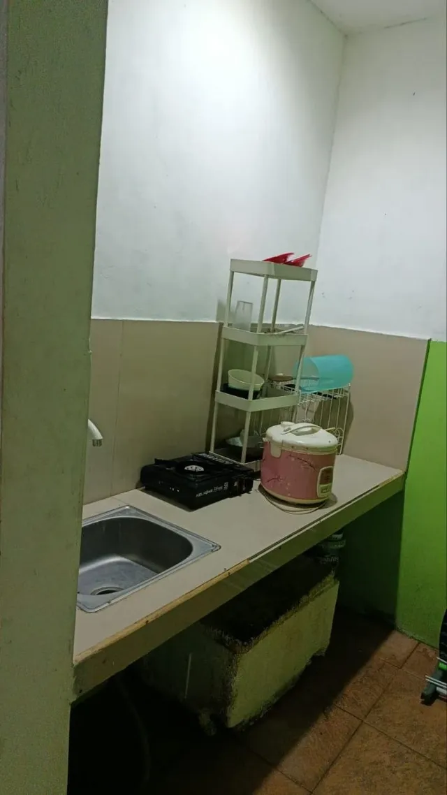 Sesudah: meja dapur kos bersih, bak cuci kosong, kompor dan rice cooker tertata, peralatan di rak