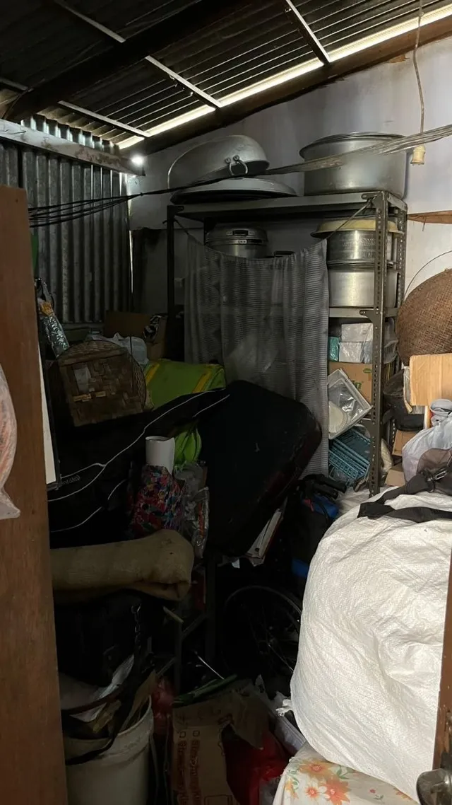 Sebelum: gudang di dapur belakang penuh tumpukan karung, tas, ember, dan barang lain di depan rak berisi panci