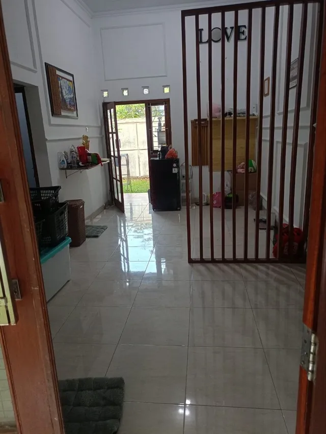 Sesudah: ruang depan dengan lantai keramik yang lega dan bersih, difoto dari sudut lain