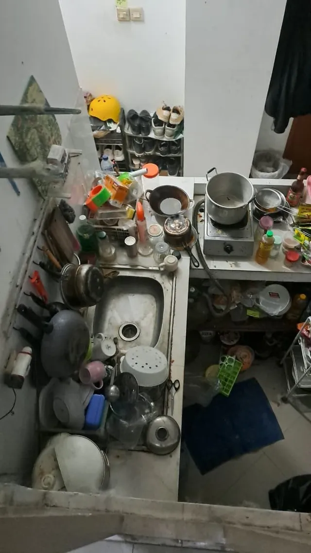 Sebelum: tampak atas bak cuci piring penuh panci, piring, dan peralatan masak, meja kompor penuh botol dan barang